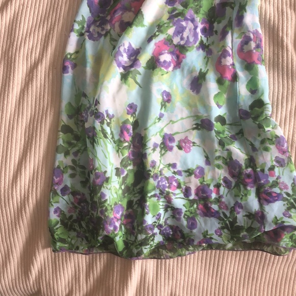 This is a floral jumpsuit with a scarf attached to the top of it on one side. - Picture 2 of 7